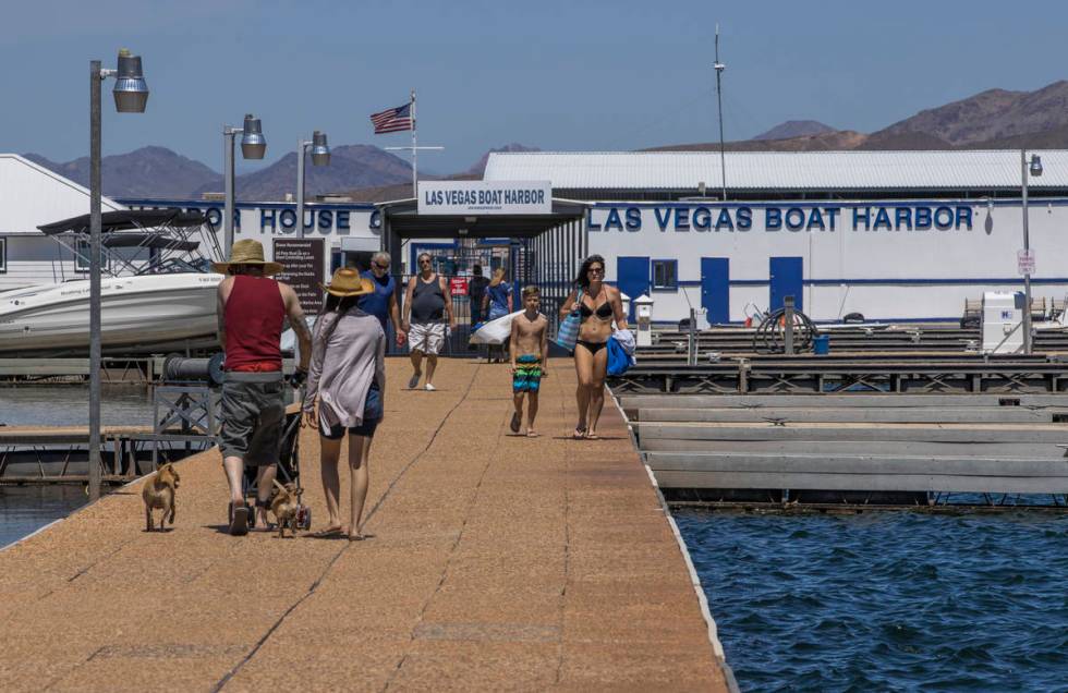 Visitors walk on the pier at the Las Vegas Boat Harbor in the Lake Mead National Recreation Are ...