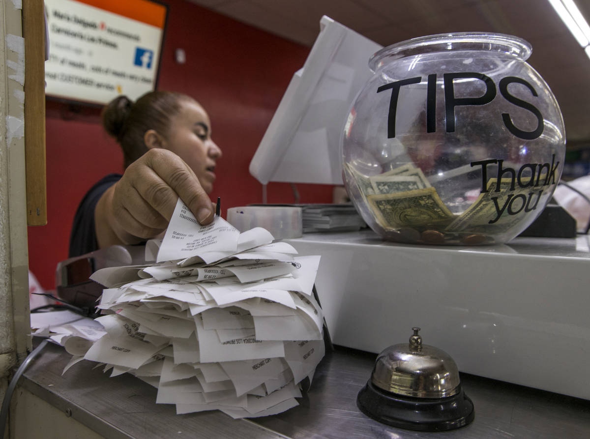 Sandy Nuno stacks up another of the day's receipts from a customer at the Los Primos Meat Marke ...