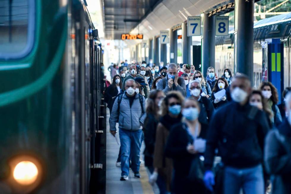 Commuters crowd Cadorna train station in Milan, Italy, Monday, May 4, 2020. Italy began stirri ...