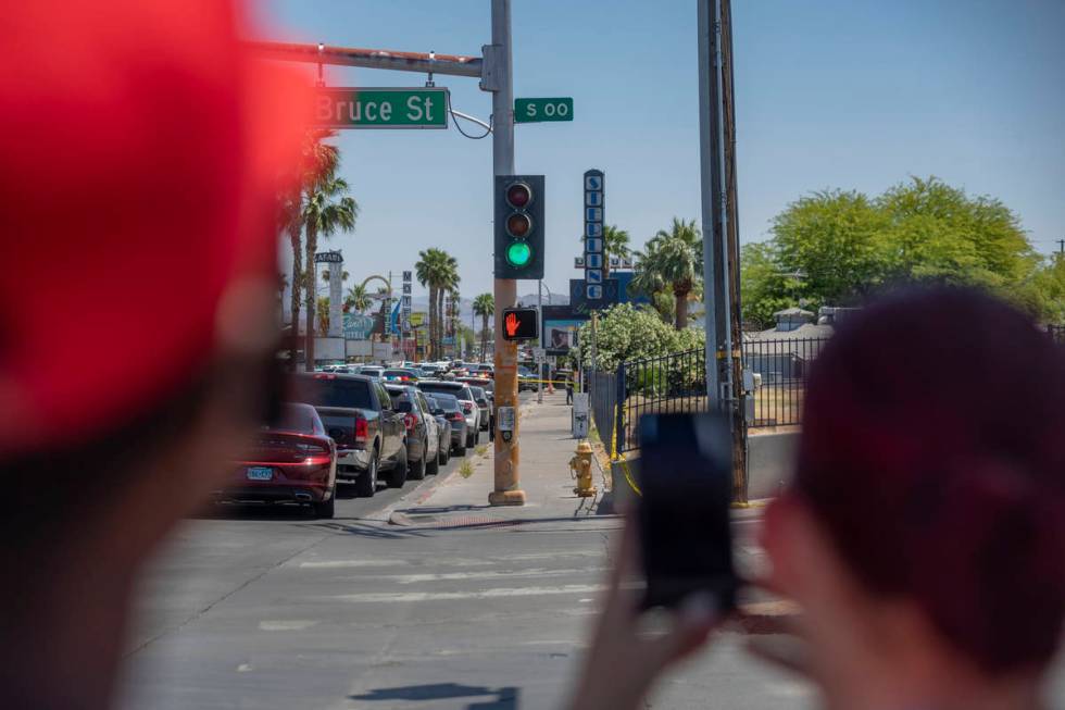 Individuals watch as the Las Vegas police investigate a downtown shooting in the 1900 block of ...