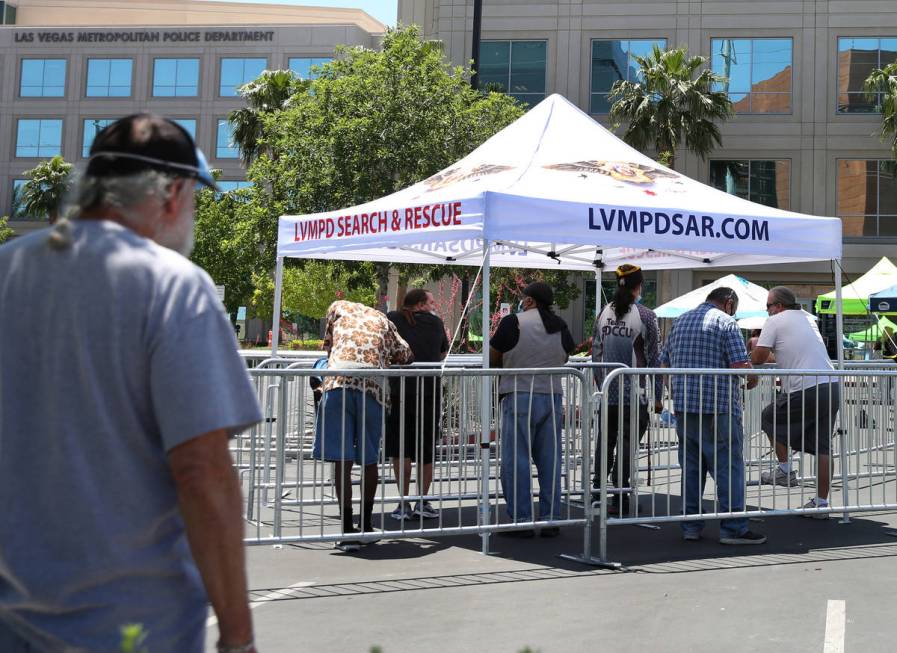 People lined up under a tent outside of the Las Vegas Metropolitan Police Department headquarte ...