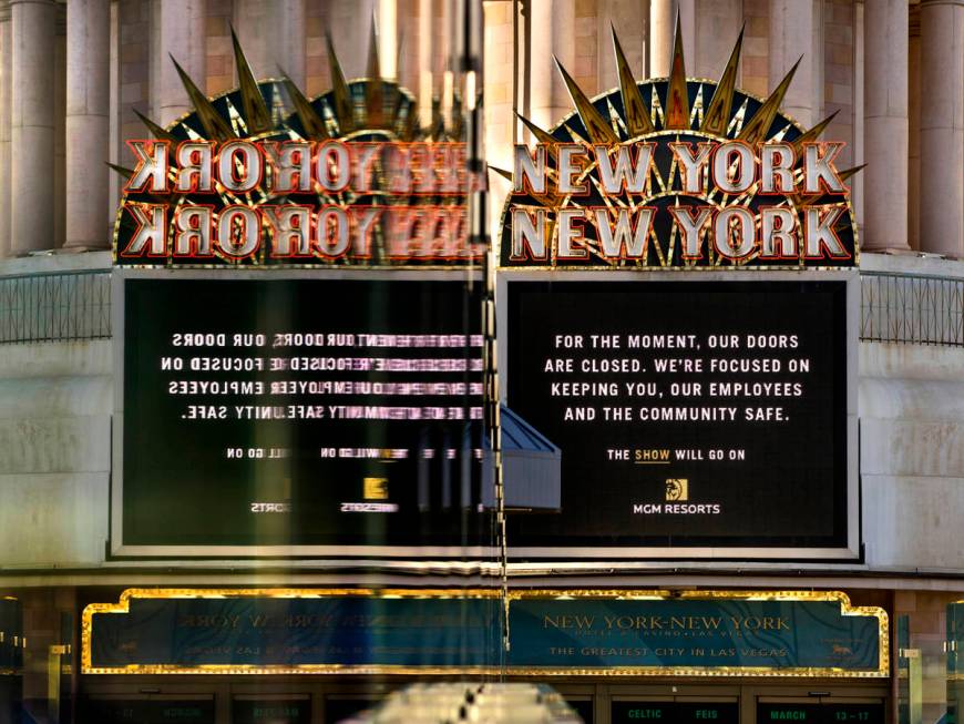 A New-York New-York sign is reflected in pedestrian bridge glass along Las Vegas Boulevard on t ...