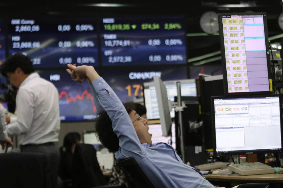 A currency trader stretches at the foreign exchange dealing room of the KEB Hana Bank headquart ...