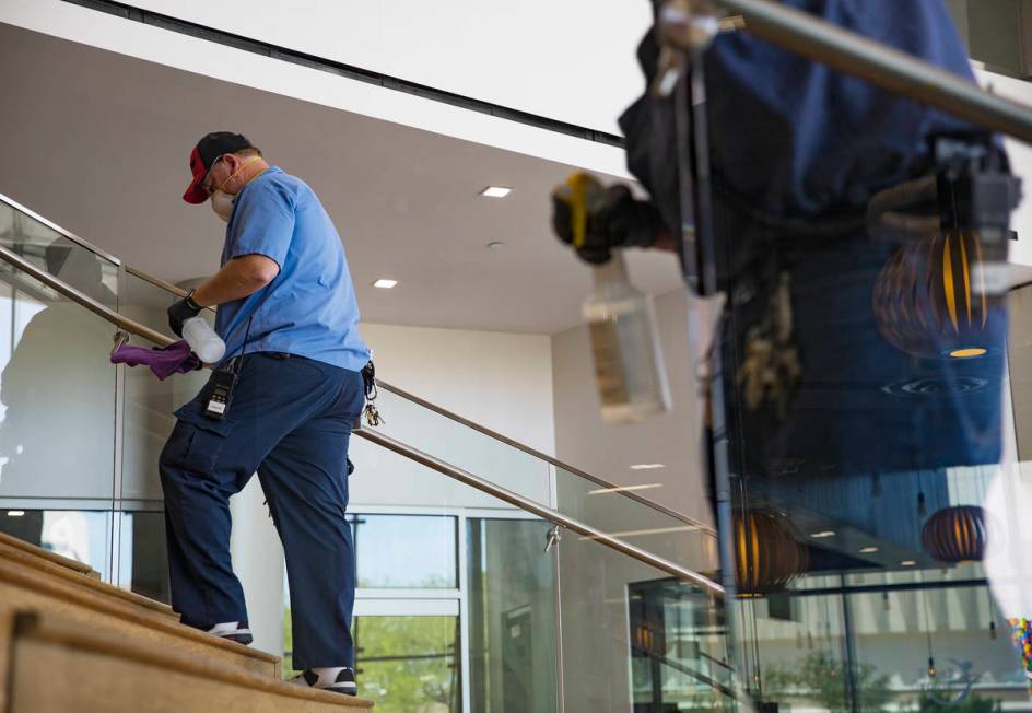 Robert Lucas, left, a custodian supervisor, and custodian Jarrell Siler, right, sanitize handra ...