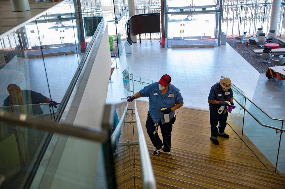 Robert Lucas, left, a custodian supervisor, and custodian Jarrell Siler, right, sanitize handra ...