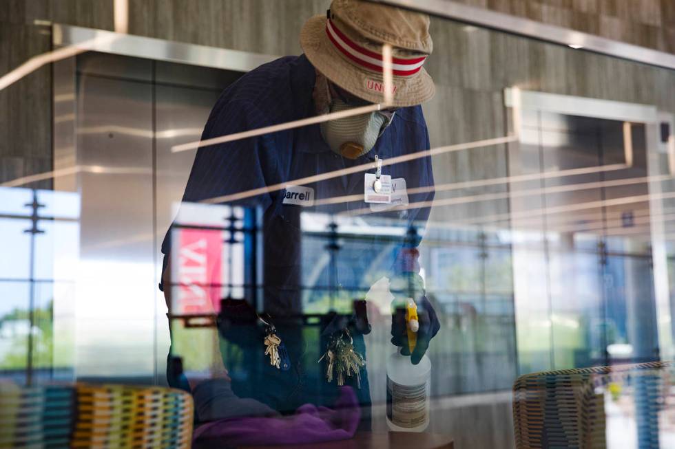 Custodian Jarrell Siler sanitizes tables and chairs in the Hospitality Hall at UNLV in Las Vega ...