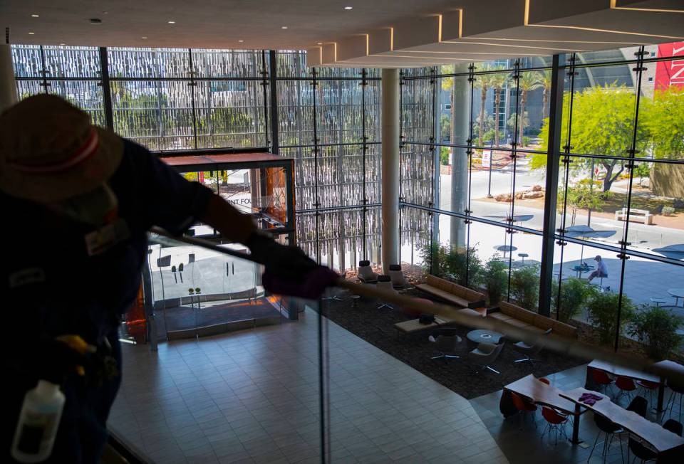 Custodian Jarrell Siler sanitizes handrails in the Hospitality Hall at UNLV in Las Vegas, Thurs ...