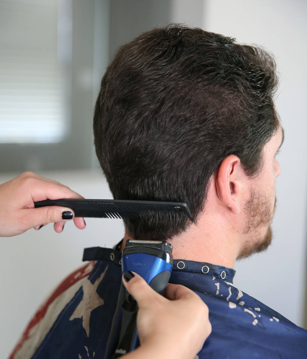 Brittany Seitz, a cosmetologist, cuts her husband's, Michael, hair as she demonstrates how to c ...