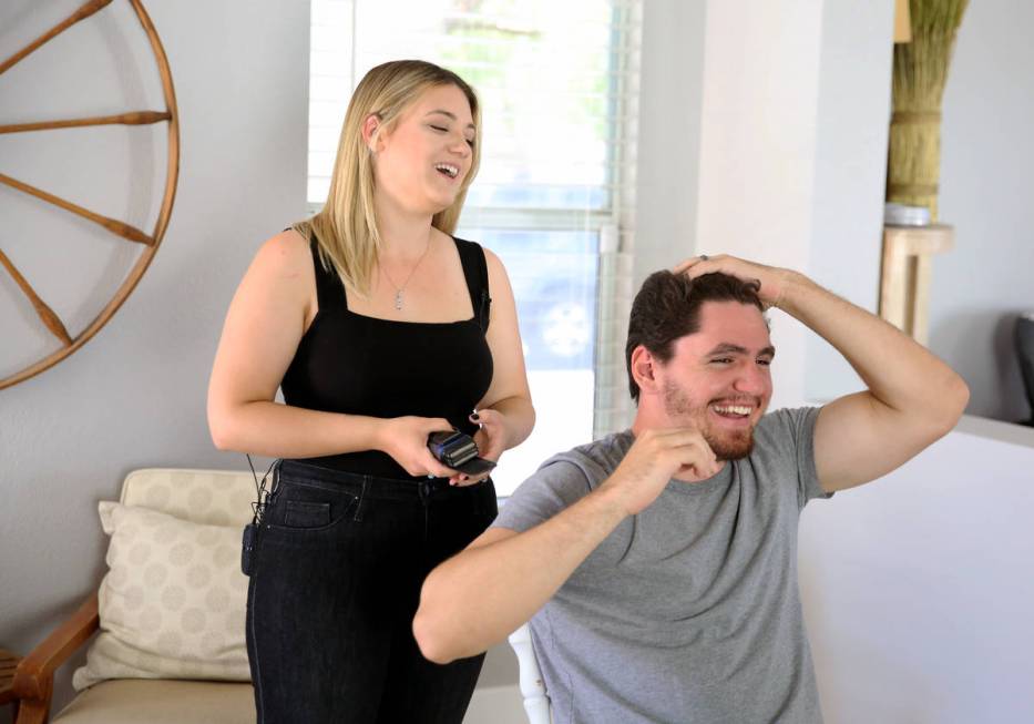 Brittany Seitz, a cosmetologist, prepares to cut her husband's, Michael, hair as she demonstrat ...