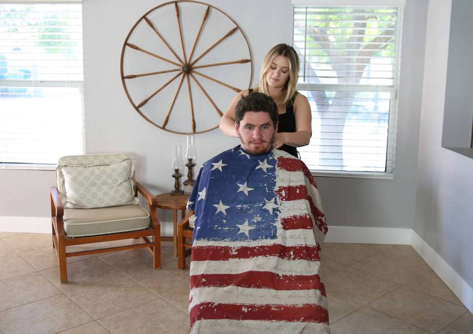 Brittany Seitz, a cosmetologist, prepares to cut her husband's, Michael, hair as she demonstrat ...