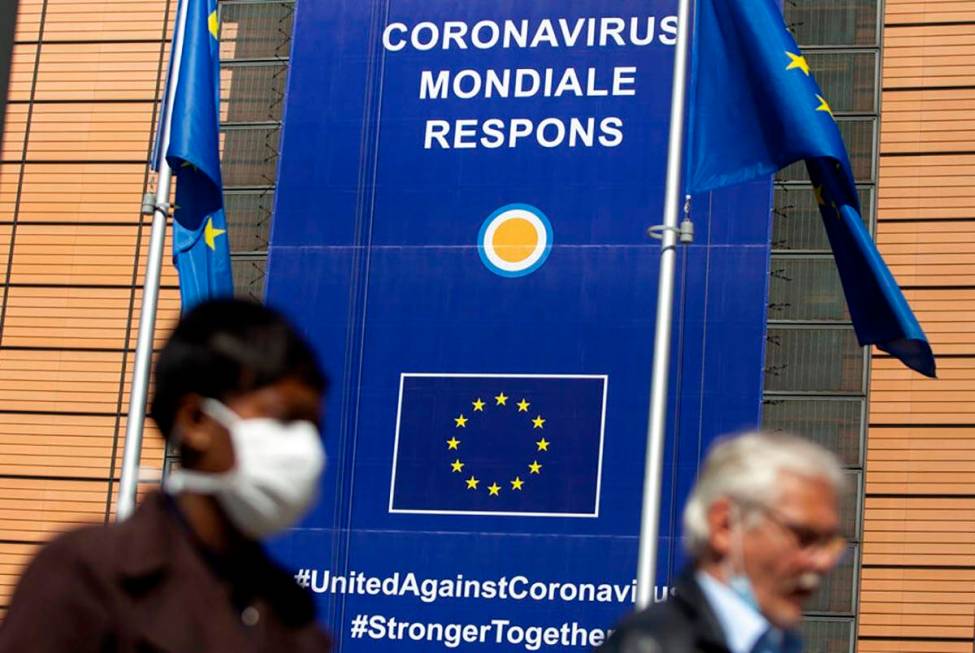 A woman wearing mouth mask, to prevent against the spread of the coronavirus, COVID-19, walks p ...