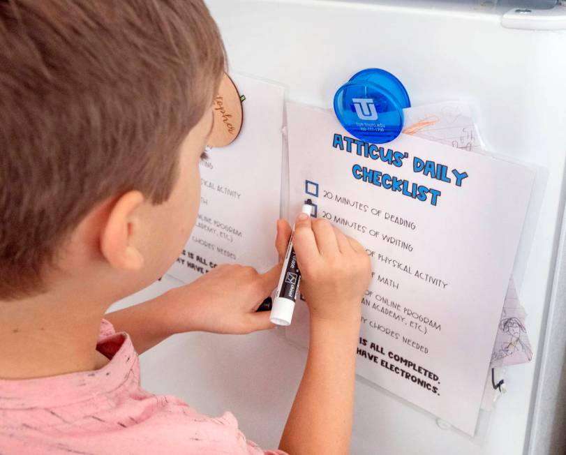 Atticus Mayville, 7, crosses off his school checklist at his home in Henderson on Thursday, May ...