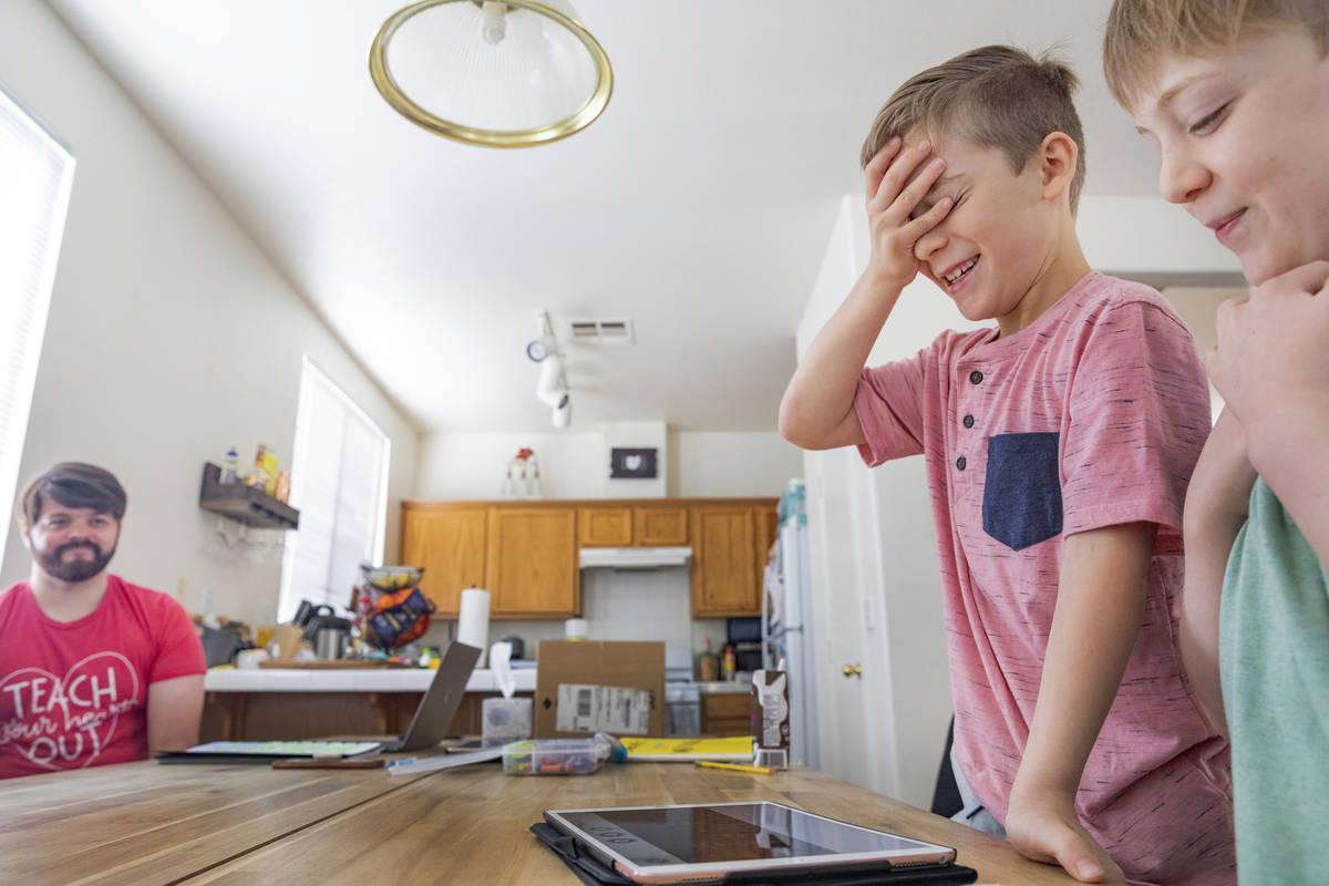 Atticus Mayville, 7, left, and Everett Mayville, 7, work on a music course for school at home w ...