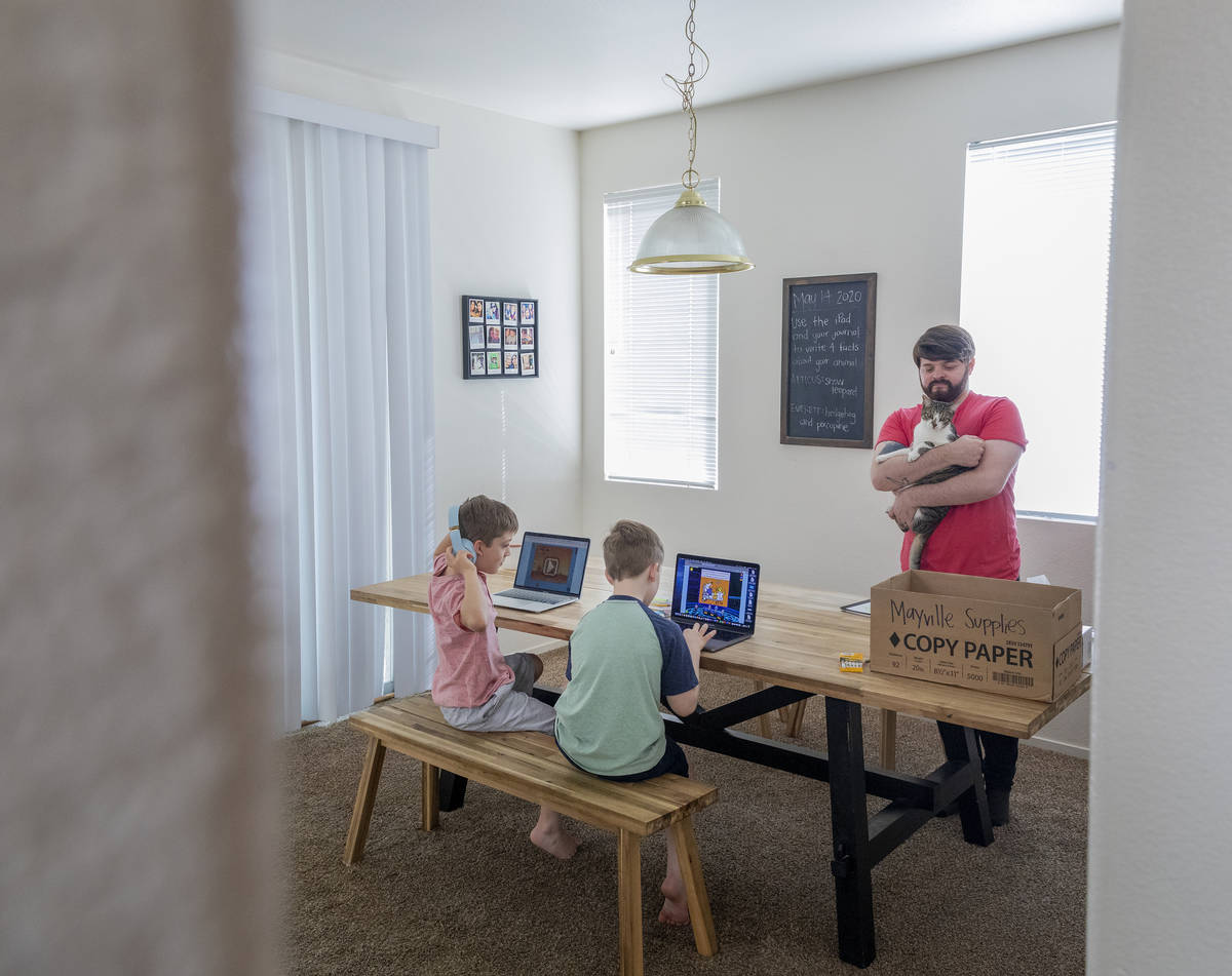 Atticus Mayville, 7, left, and Everett Mayville, 7, work on school projects with help from thei ...