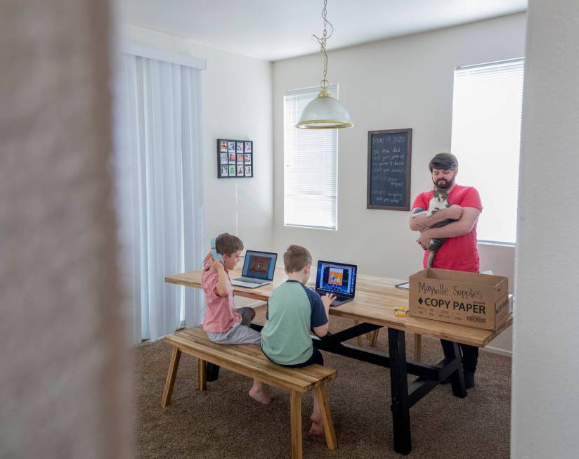 Atticus Mayville, 7, left, and Everett Mayville, 7, work on school projects with help from thei ...