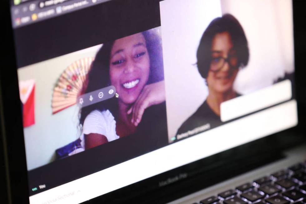 Orchestra teacher Coco Jenkins Thomas, left, talks to her 8th-grade-student Zachary Pearl using ...