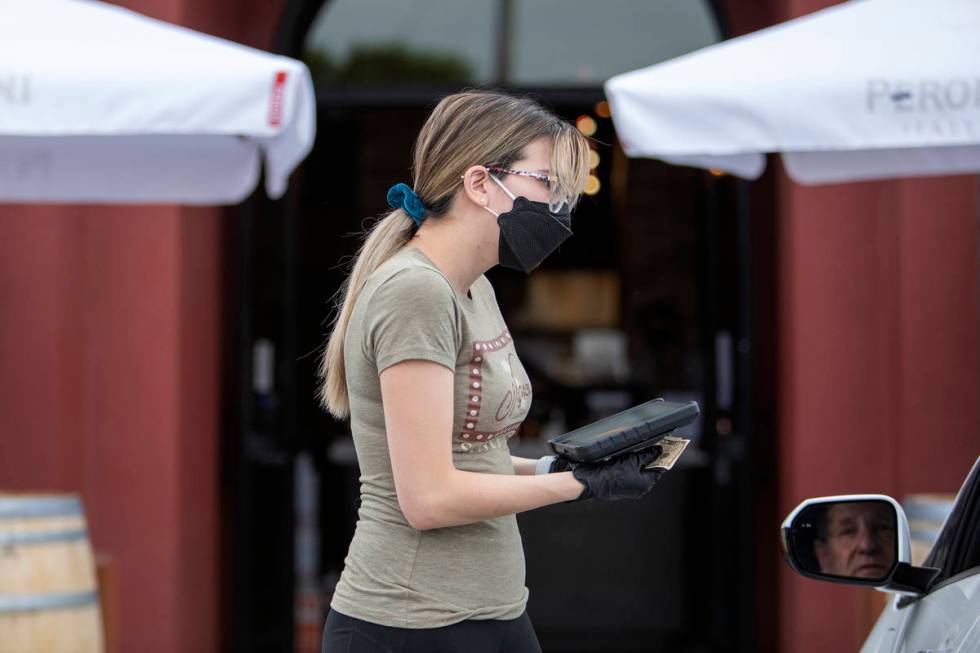 Michelle Villalpando takes payment for Ted Powell's curbside pickup order at Nora's Italian Cui ...