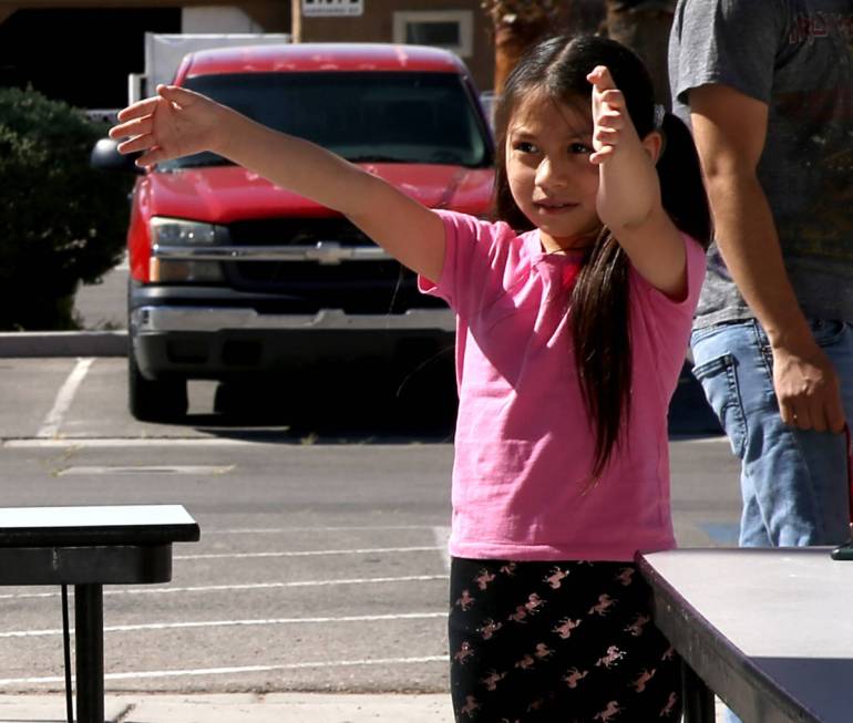 Emely Carreon, 7, a second grader at Martinez Elementary, gives her teacher-librarian Nichole B ...