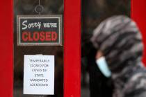 A pedestrian walks by The Framing Gallery, closed due to the COVID-19 pandemic, in Grosse Point ...