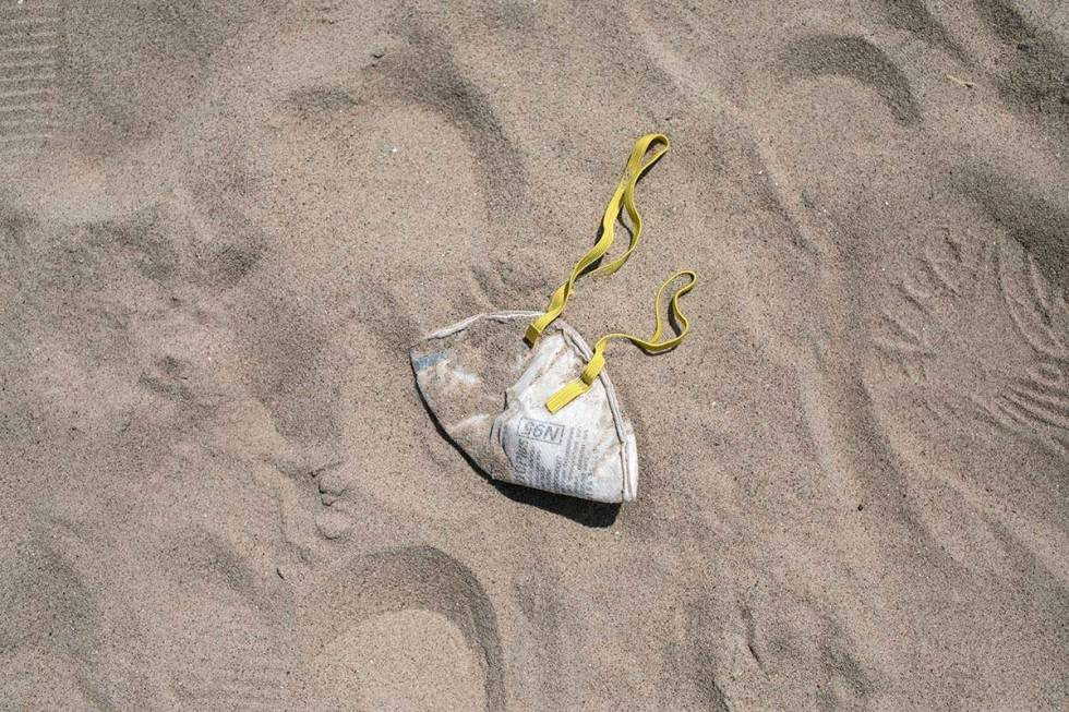 An N95 protective face mask lies in the sand on Brighton Beach in the Brooklyn borough of New Y ...