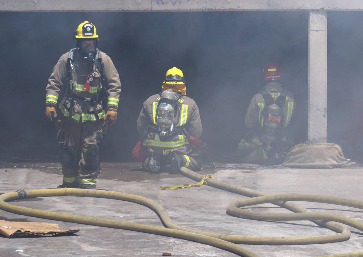 Henderson firefighters battle a fire in a storm drain that generated a large amount of smoke on ...