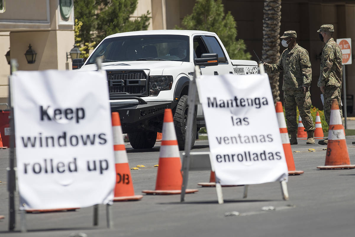 Members of the Nevada National Guard direct a person at the COVID-19 drive-through testing at ...