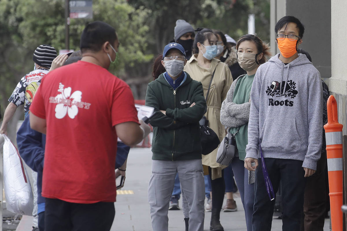 A line of people wait to enter a Trader Joe's grocery store during the coronavirus outbreak in ...