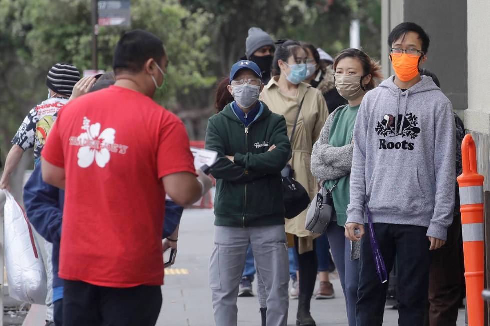 A line of people wait to enter a Trader Joe's grocery store during the coronavirus outbreak in ...