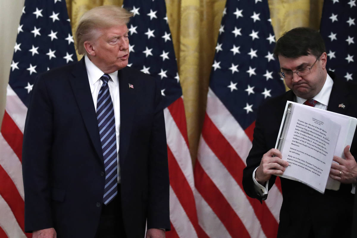 President Donald Trump watches as Veterans Affairs Secretary Robert Wilkie walks away after spe ...