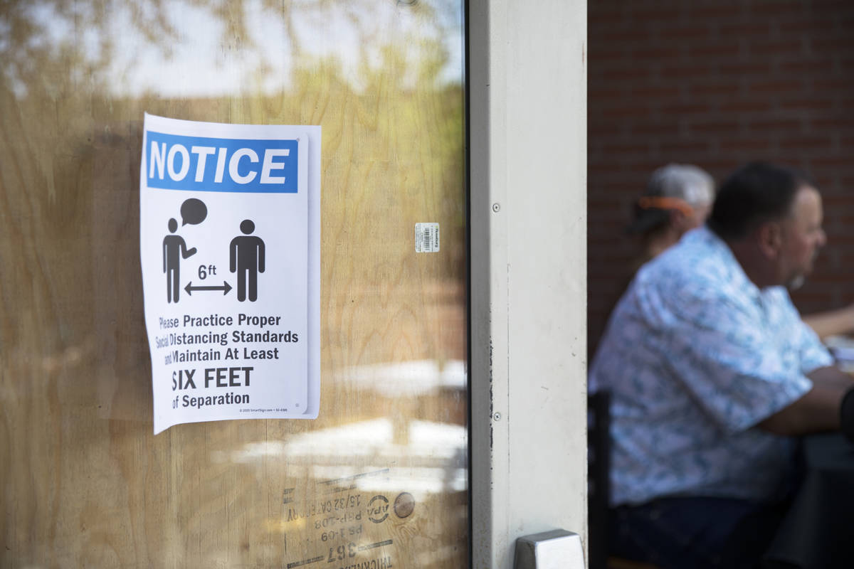 A sign to inform guests of social distancing measures on the door at 7th & Carson in Las Ve ...