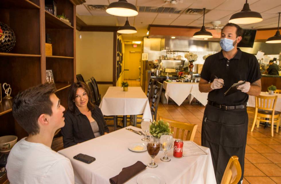 Diners Seth Andress, left, and his mother Lou have their order's taken by waiter Brennen Rudack ...