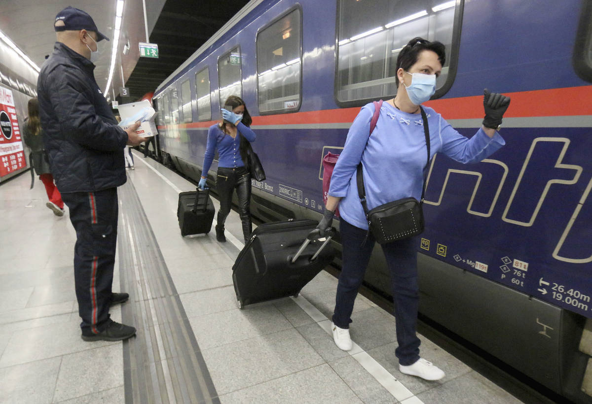 Romanian care workers with face masks accompanied by police and security arrive at the train st ...