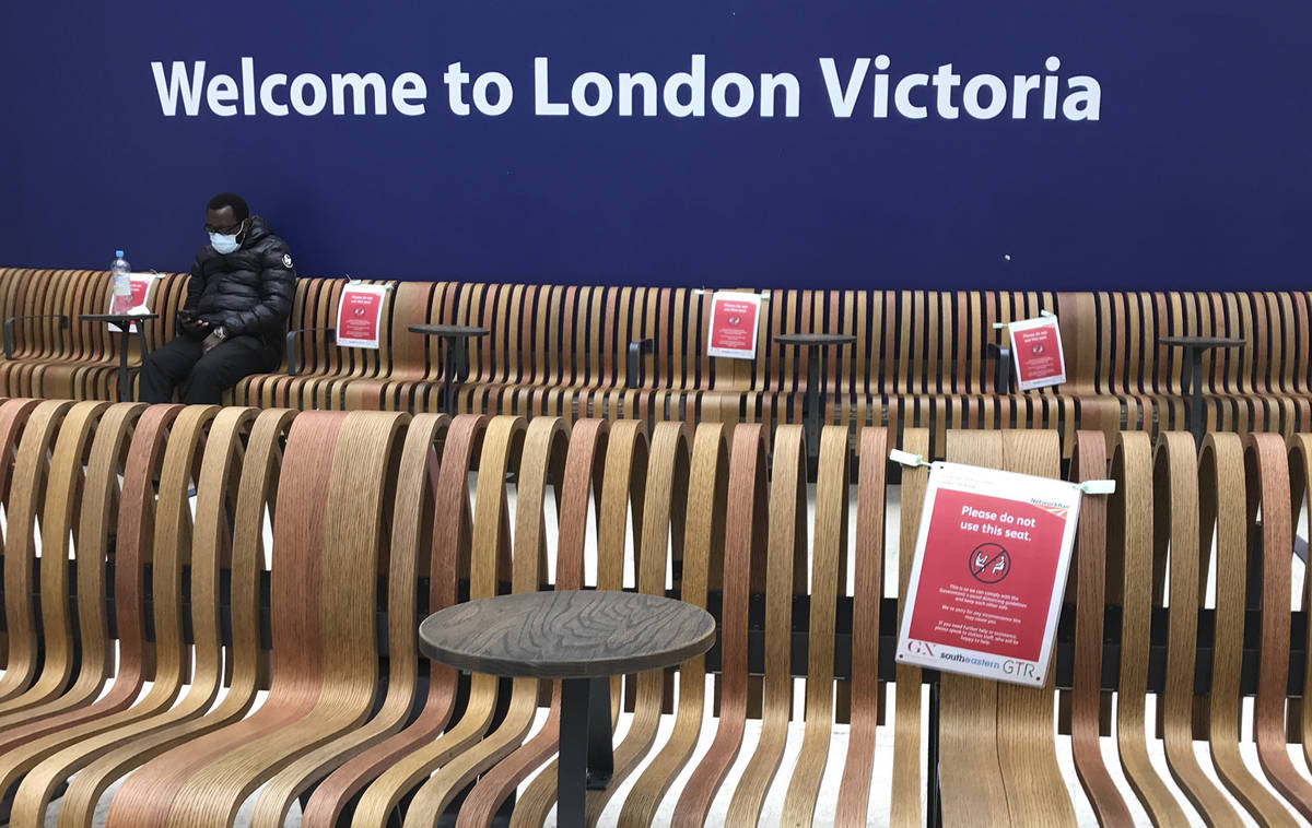 Seats displaying social distancing signs at Victoria Station, London, Monday, May 11, 2020, as ...