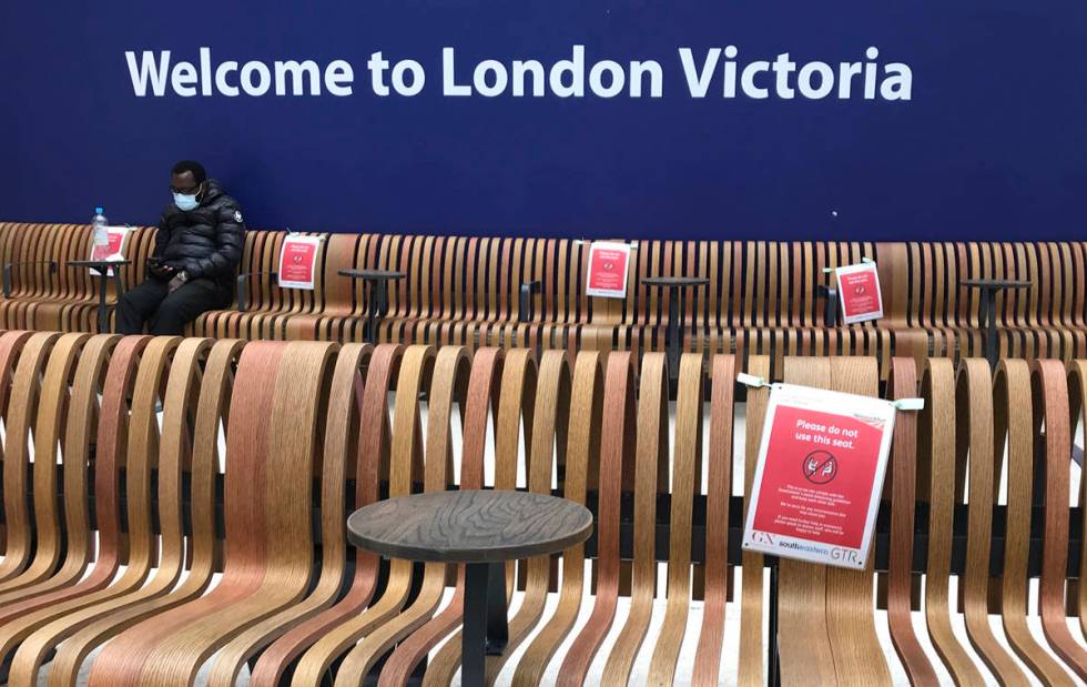 Seats displaying social distancing signs at Victoria Station, London, Monday, May 11, 2020, as ...