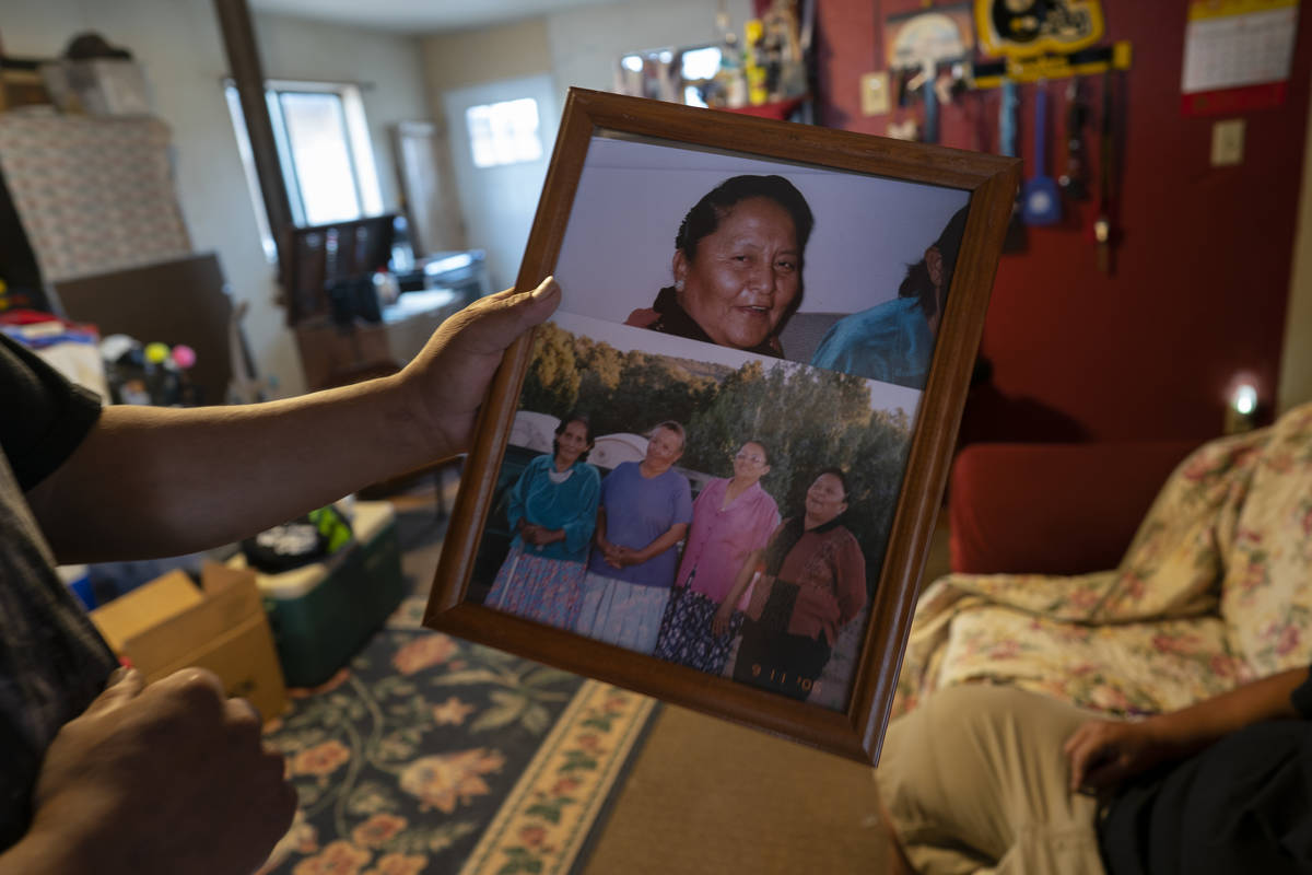 Eugene Dinehdeal holds photos of family members, including Eva Dinehdeal at top, at the Dinehde ...