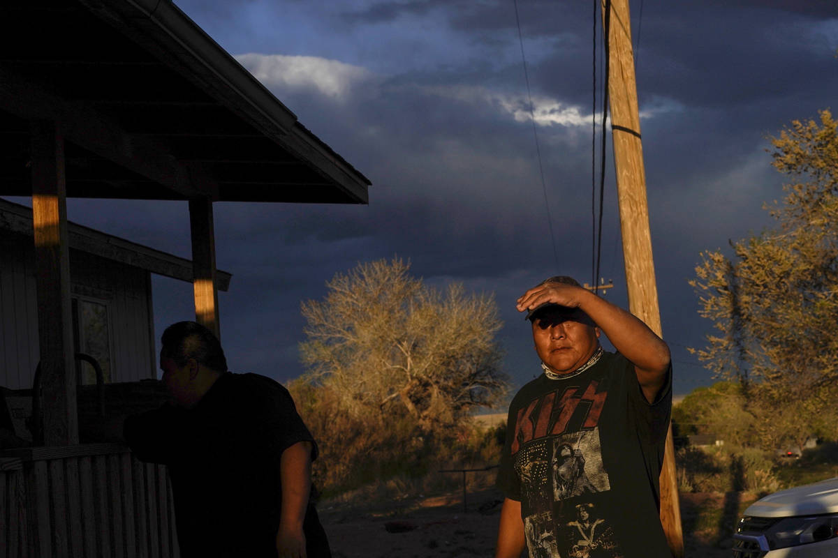 Eugene Dinehdeal shields his face from the setting sun on the Dinehdeal family compound in Tuba ...