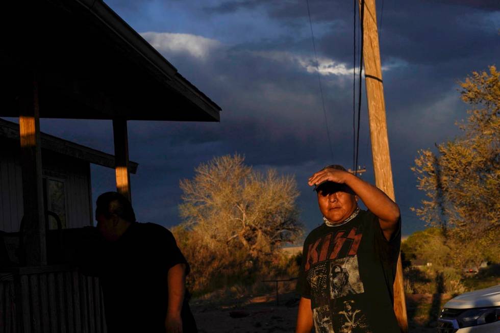 Eugene Dinehdeal shields his face from the setting sun on the Dinehdeal family compound in Tuba ...