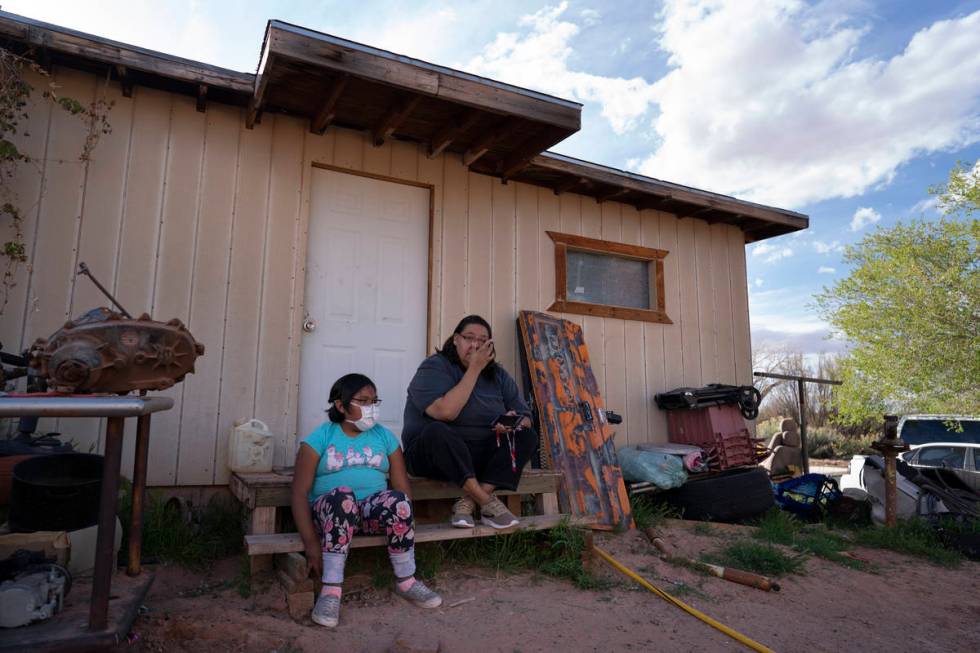 Angelina Dinehdeal wipes tears from her eyes as she sits with her 8-year-old daughter, Annabell ...