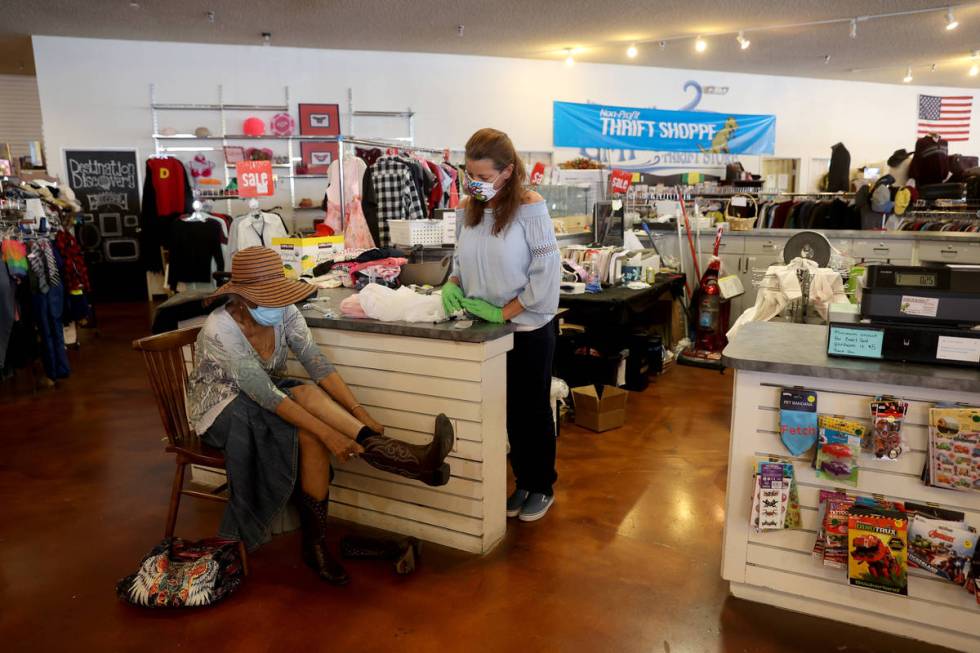 Dinosaurs & Roses customer Barbara Tillard, 85, tries on boots with store assistant Jennife ...