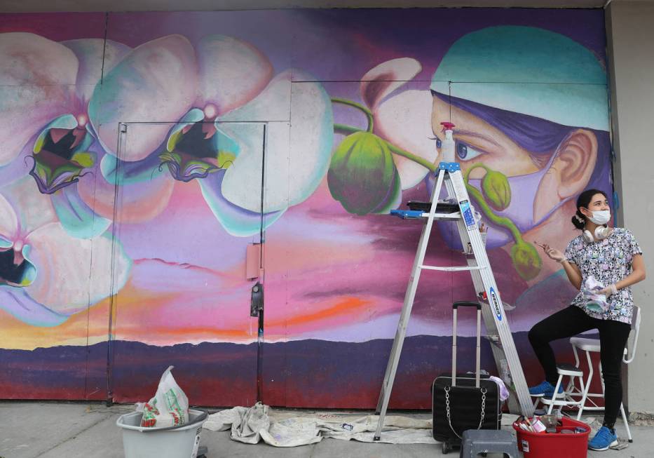 Chelsea Rust, muralist and staff of Priscilla Fowler Fine Art, paints a mural of a Las Vegas Va ...