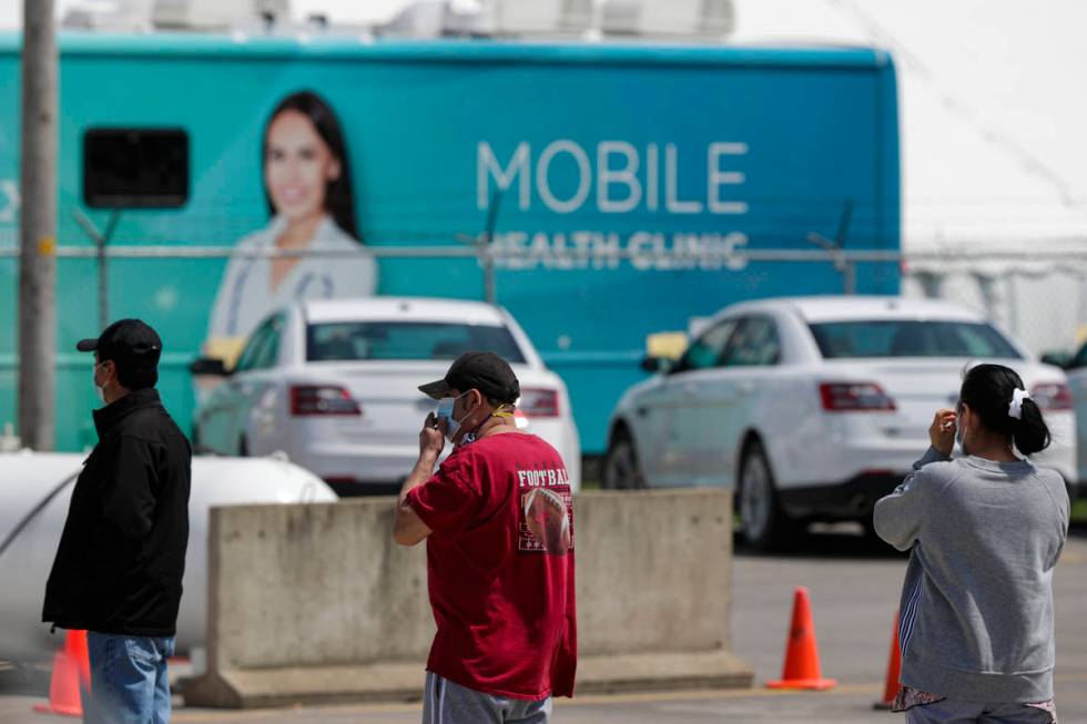 Workers line up to enter the Tyson Foods pork processing plant in Logansport, Ind., Thursday, M ...