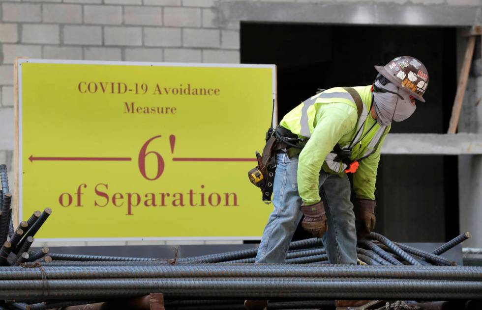 FILE - In this April 9, 2020, file photo, a construction worker wears a protective mask during ...