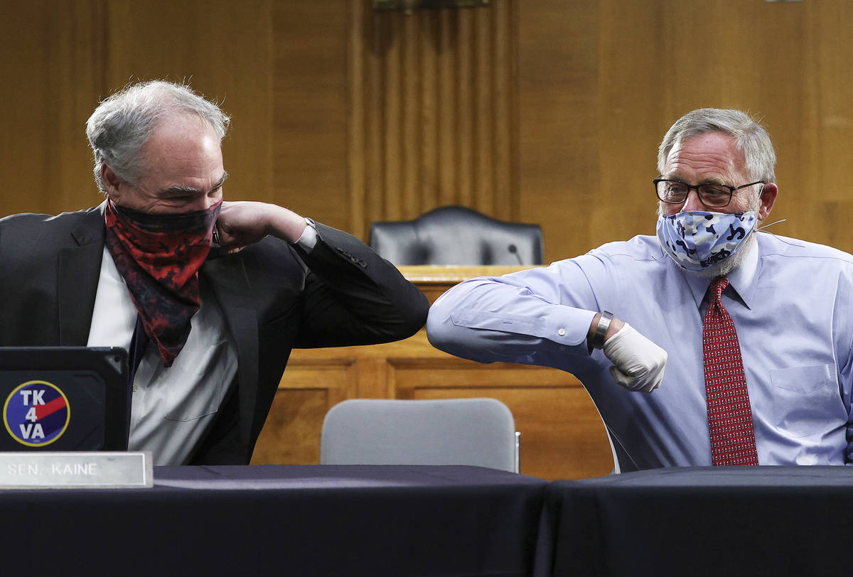 Sen. Tim Kaine, D-Va., left, and Sen. Richard Burr, R-N.C., greet each other with an elbow bump ...