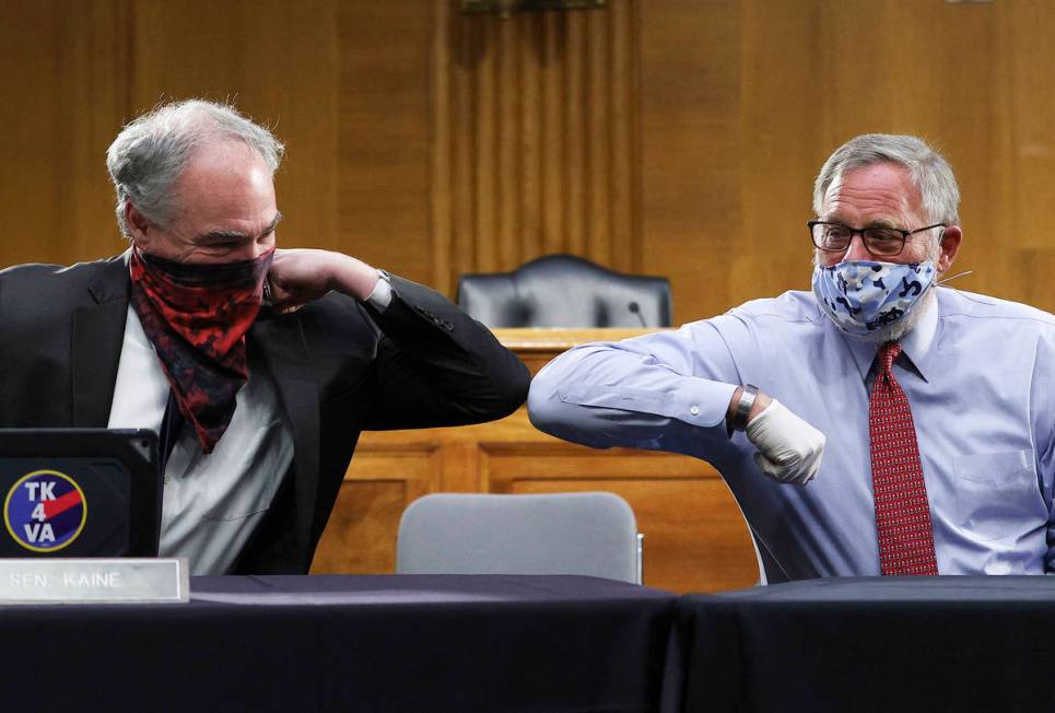 Sen. Tim Kaine, D-Va., left, and Sen. Richard Burr, R-N.C., greet each other with an elbow bump ...