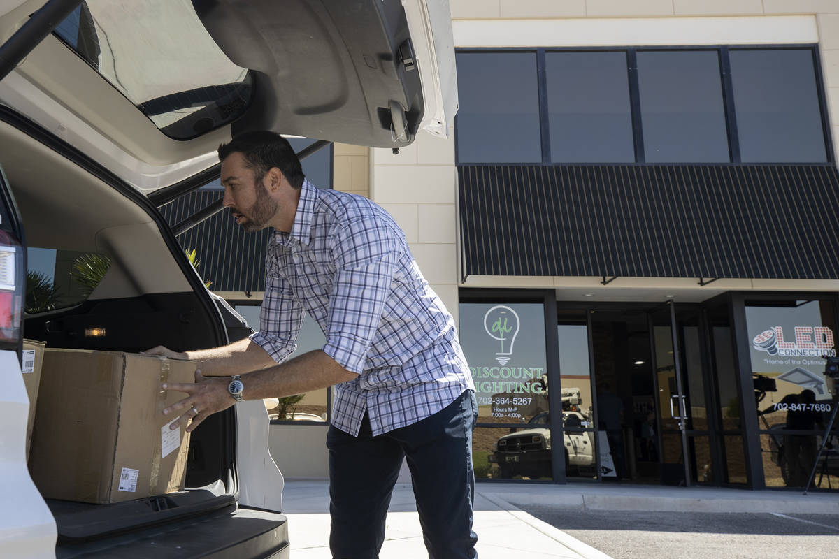 Eagle Promotions co-owner Sean Ono loads donated masks for delivery on Wednesday, May 13, 2020 ...