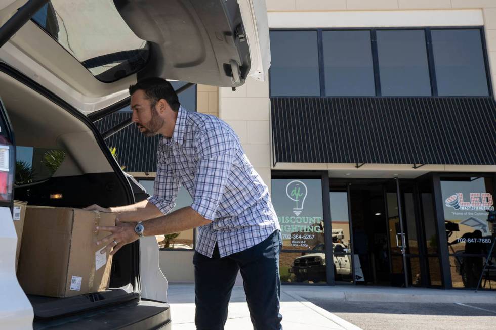 Eagle Promotions co-owner Sean Ono loads donated masks for delivery on Wednesday, May 13, 2020 ...