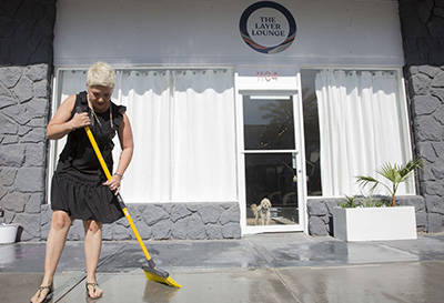 Megan Linney sweeps up the side walk in front of her downtown Las Vegas skin care salon, The La ...