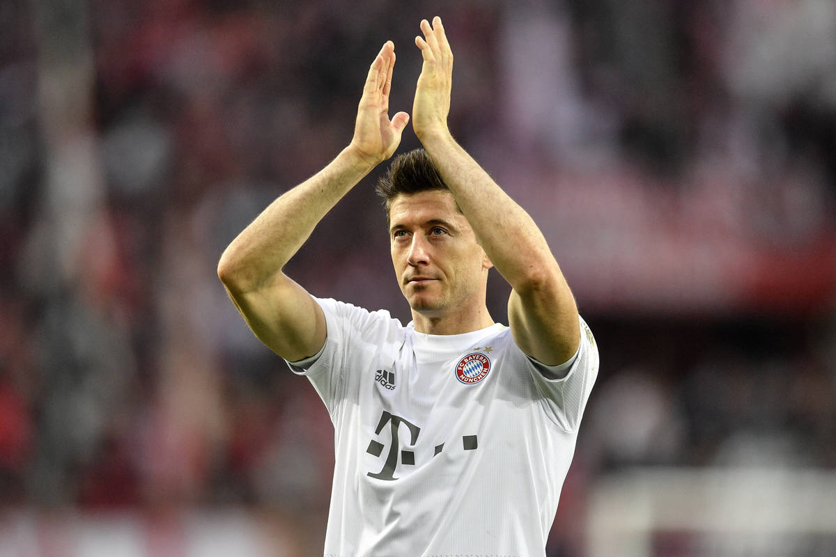 In this Sunday, Feb. 16, 2020 file photo, Bayern's Robert Lewandowski celebrates with supporter ...