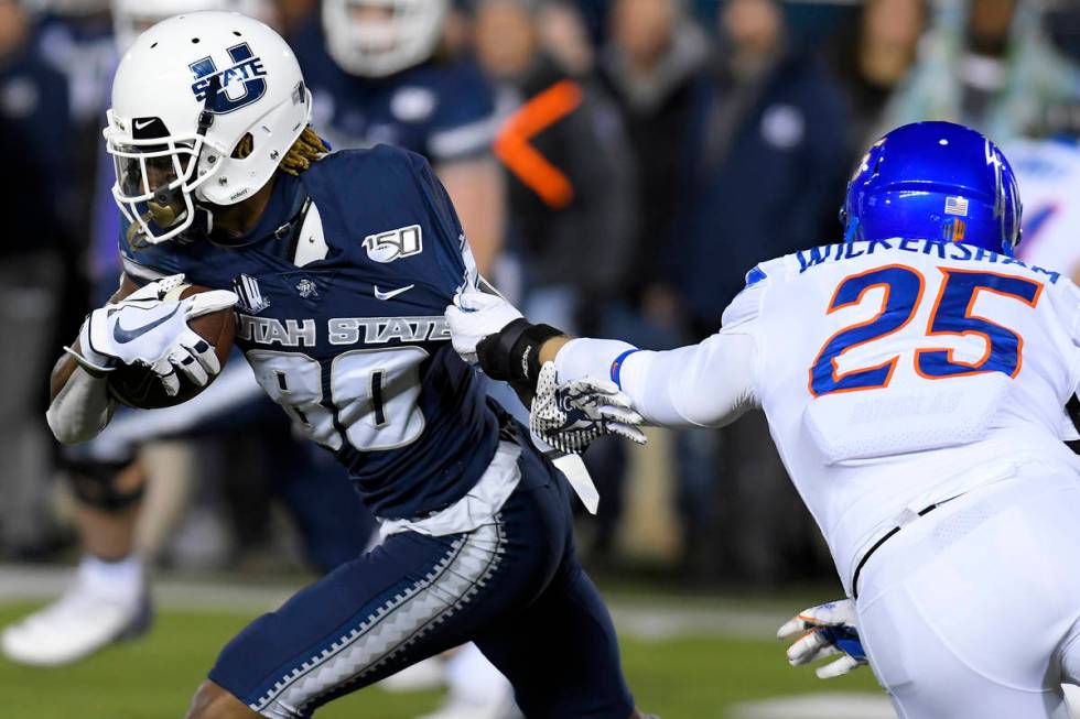 Boise State linebacker Benton Wickersham (25) tries to tackle Utah State wide receiver Siaosi M ...