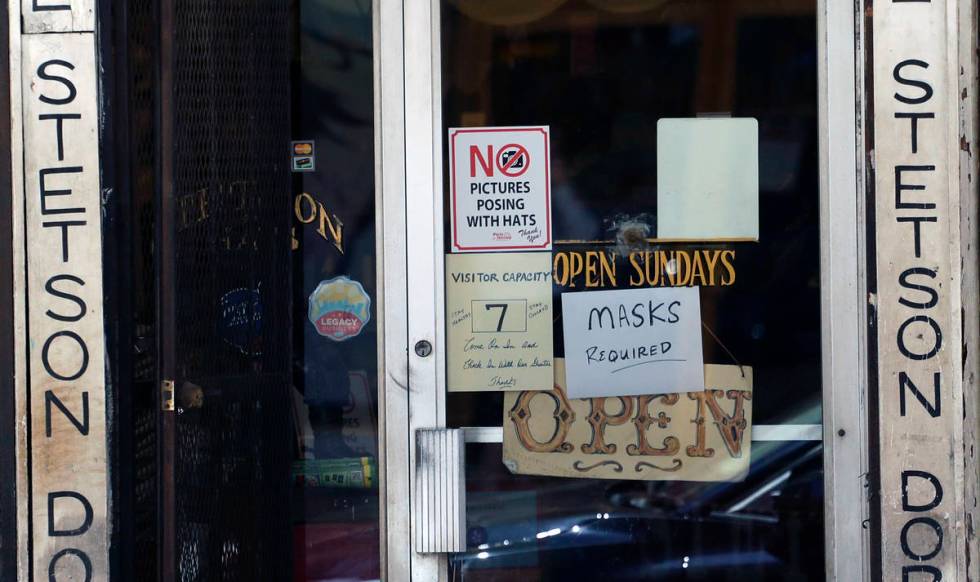 A business that had been closed due to the COVID-19 pandemic posts signage after it reopened in ...